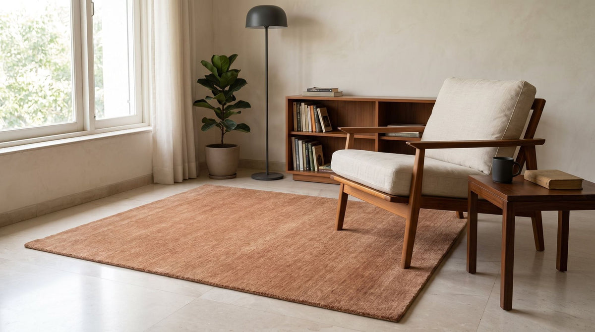 Grain Wool Rug in Russet in a styled reading corner with a teak armchair, handloom New Zealand wool.
