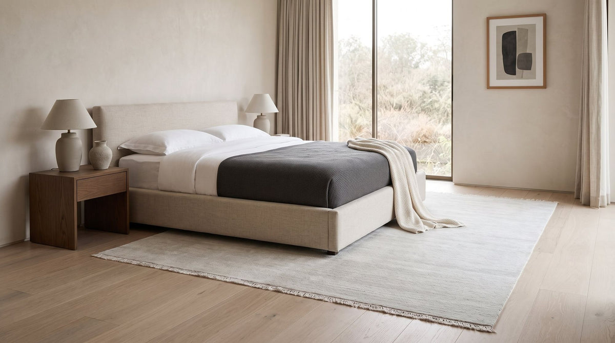 Cashmere Blend Rug in Salt in a styled bedroom, handloom wool and cashmere under a low bed.